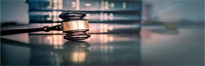 An image of a gavel in front of books on a table