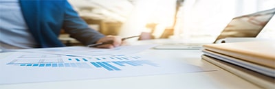 Person reading a document placed on a table with charts