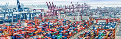Cargo shipping yard with shipping containers and cranes